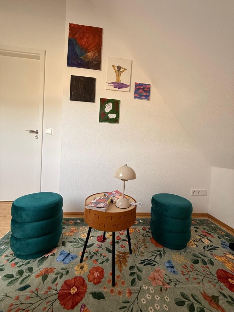 Sitzecke mit Poufs, Beistelltisch und Bilderwand unter der Dachschraege